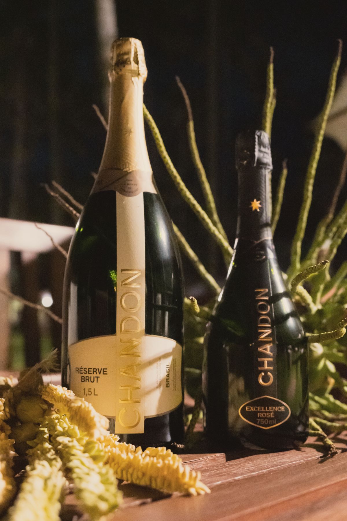 Garrafas de Chandon na mesa decorada com flores de coqueiro
