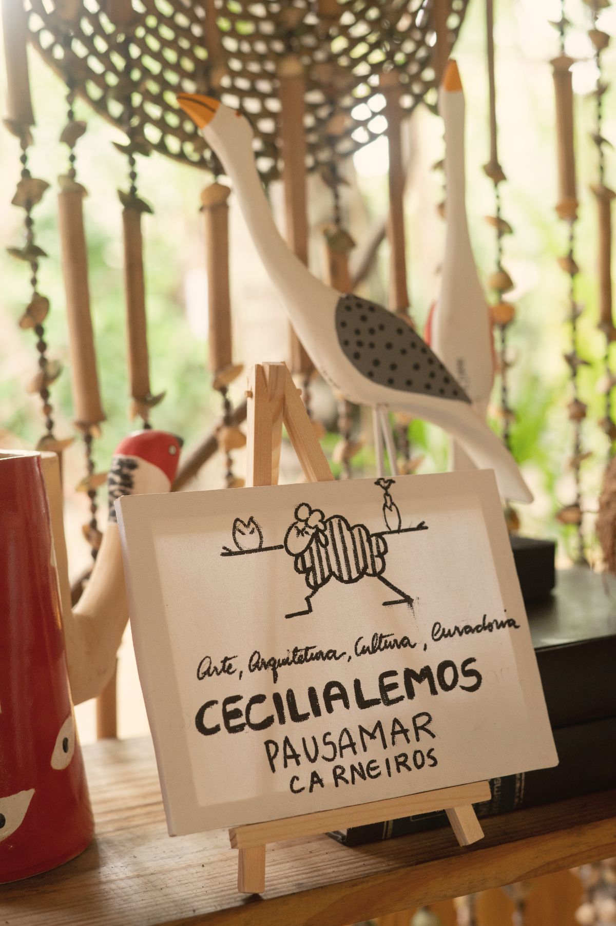 Plaquinha da curadoria de Cecília Lemos