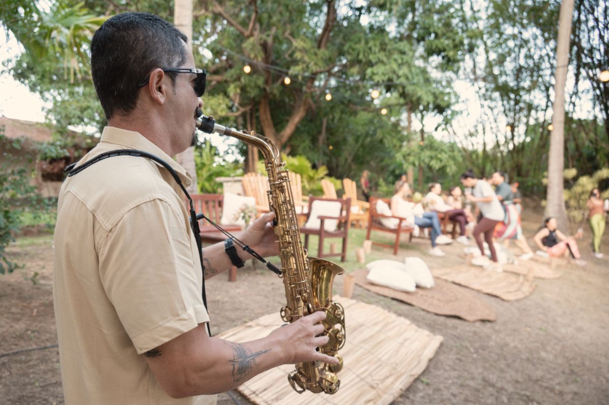 Saxofonista tocando ao ar livre para o grupo