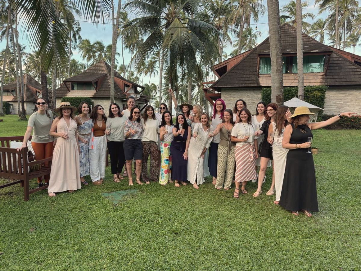 Grupo de mulheres brindando no gramado entre os bungalows