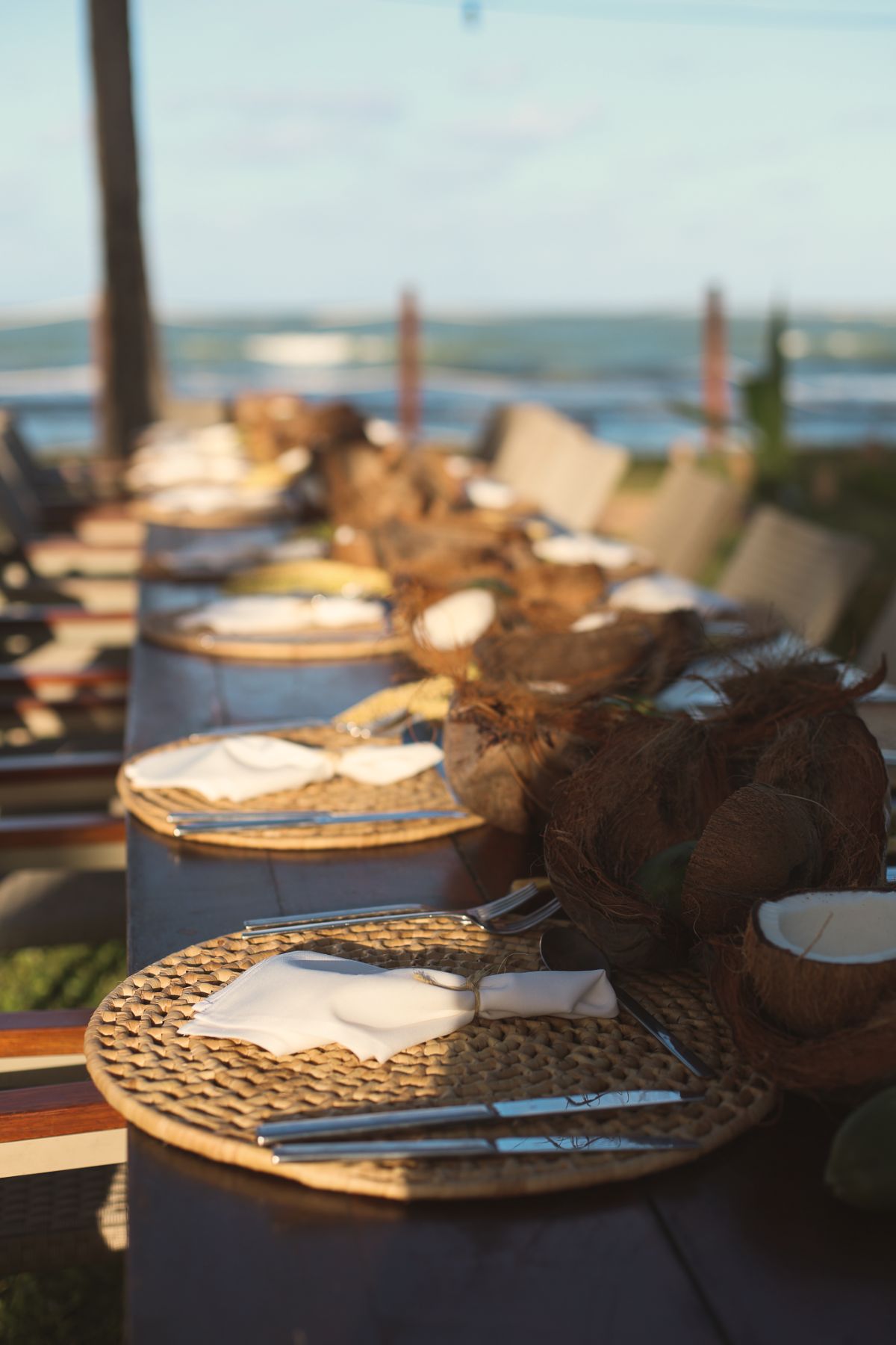 Mesa posta com cocos à beira-mar