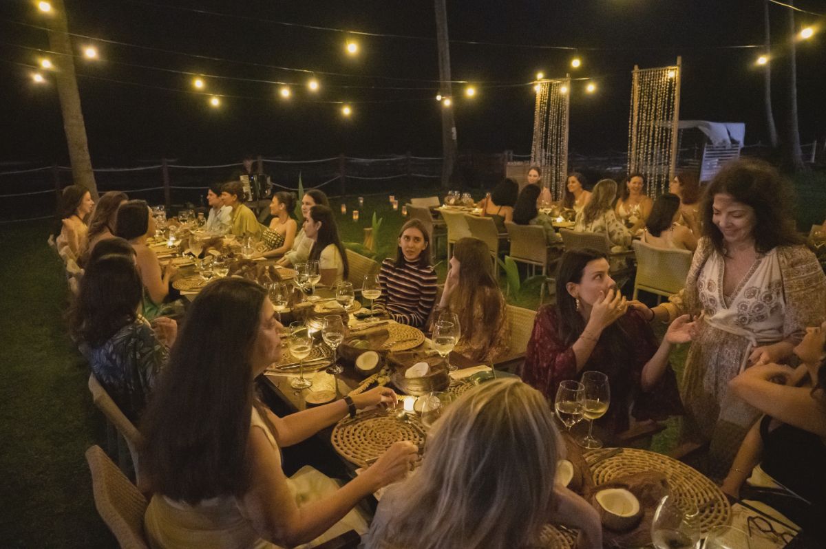 Mesa de jantar à noite, com convidadas, cocos e Chandon