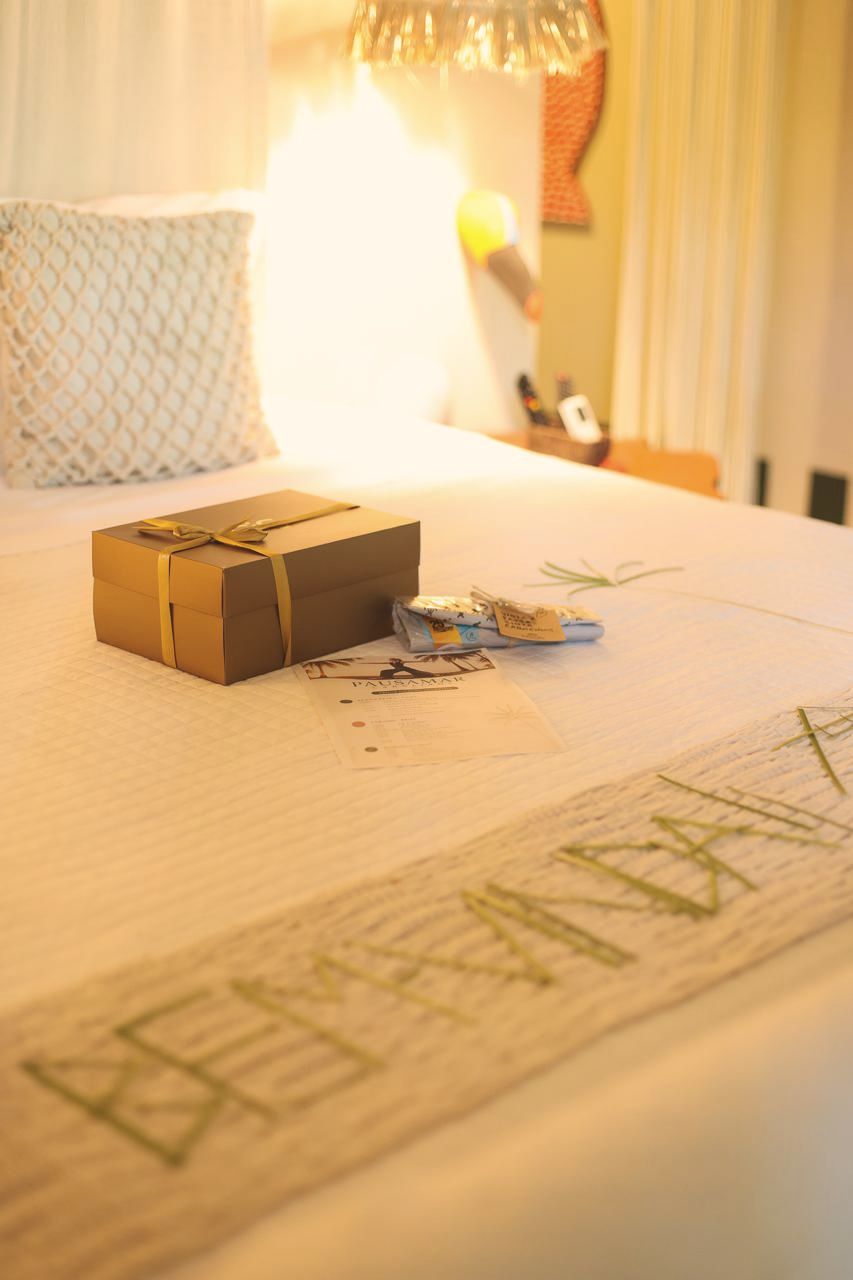 Caixa de presente sobre a cama com mensagem bem-vinda